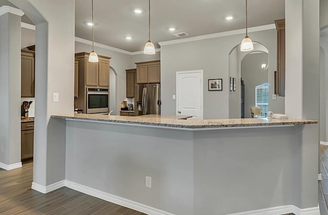 kitchen with kitchen peninsula, light stone counters, decorative light fixtures, and appliances with stainless steel finishes