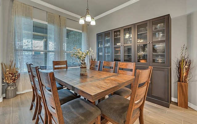 dining area with light hardwood / wood-style flooring and ornamental molding