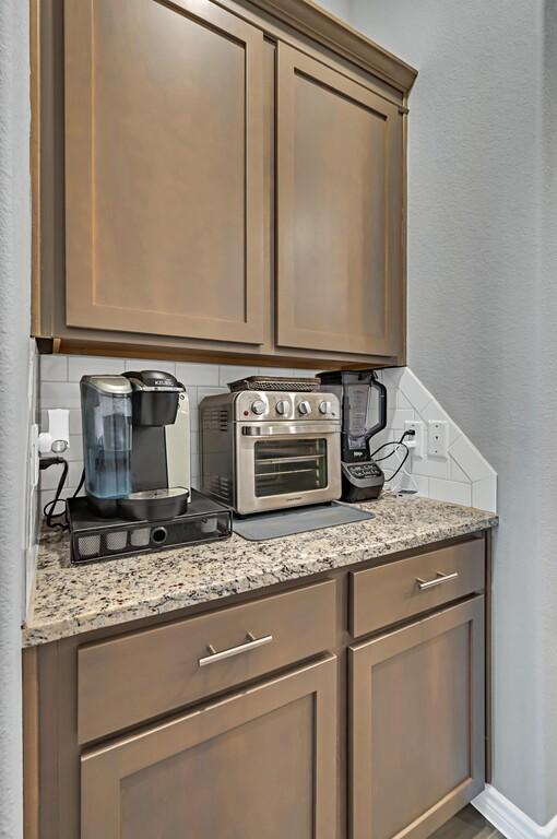 kitchen with decorative backsplash and light stone counters