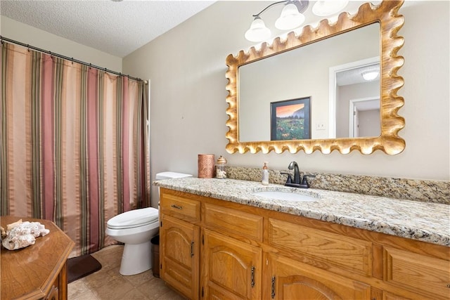 bathroom with vanity, a textured ceiling, and toilet