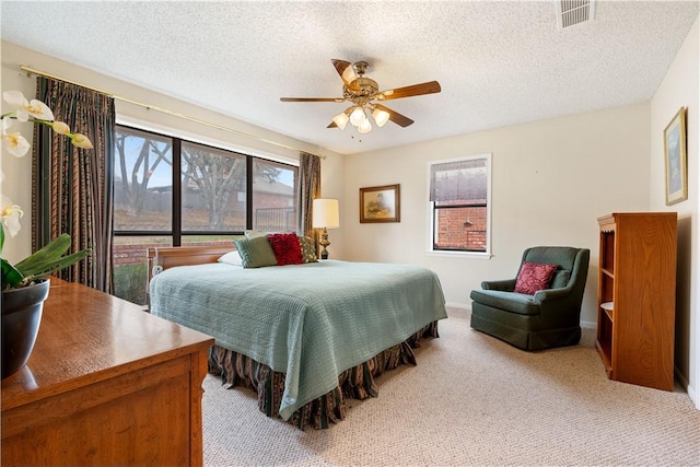 carpeted bedroom featuring ceiling fan and a textured ceiling