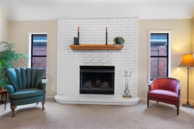 carpeted living room featuring a textured ceiling and a fireplace