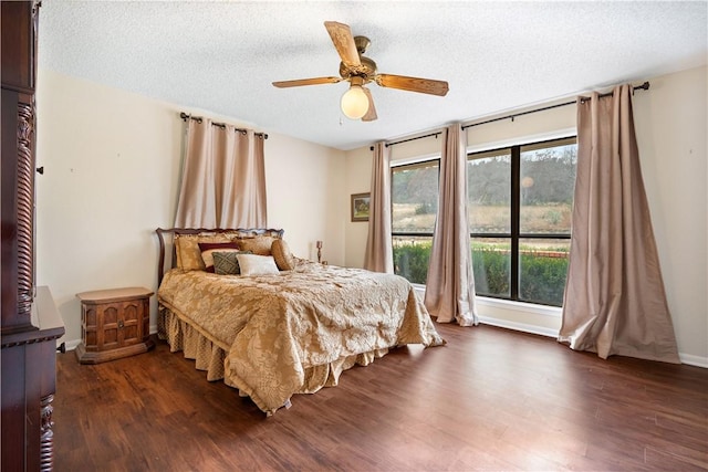 bedroom with dark hardwood / wood-style flooring, ceiling fan, and a textured ceiling