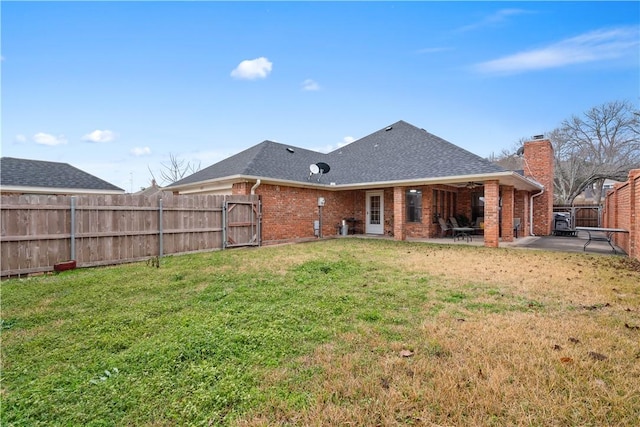 back of property featuring a patio and a lawn