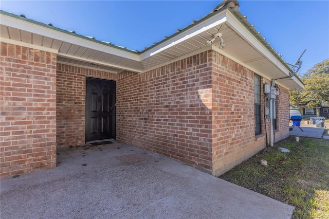 view of exterior entry featuring brick siding