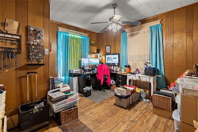 office area with hardwood / wood-style flooring, wood walls, and ceiling fan