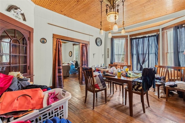 dining space with wood ceiling and wood-type flooring