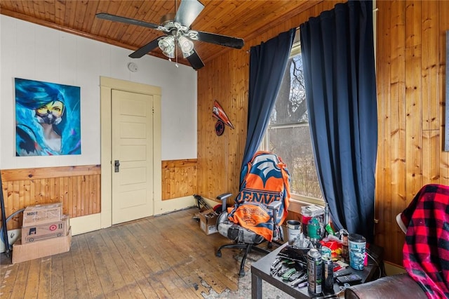 miscellaneous room featuring wooden walls, wood ceiling, hardwood / wood-style floors, and a ceiling fan