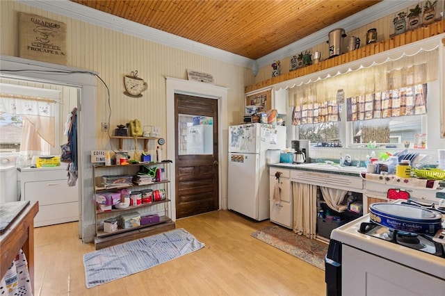 kitchen with separate washer and dryer, white appliances, light wood-style floors, and ornamental molding