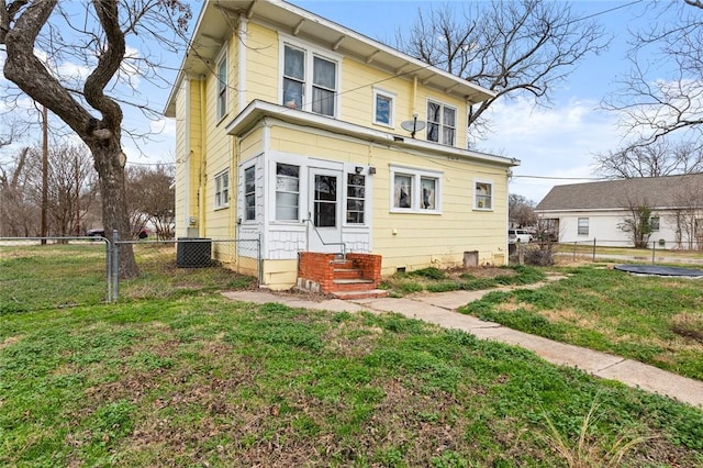 back of house with crawl space, a fenced backyard, entry steps, and a yard