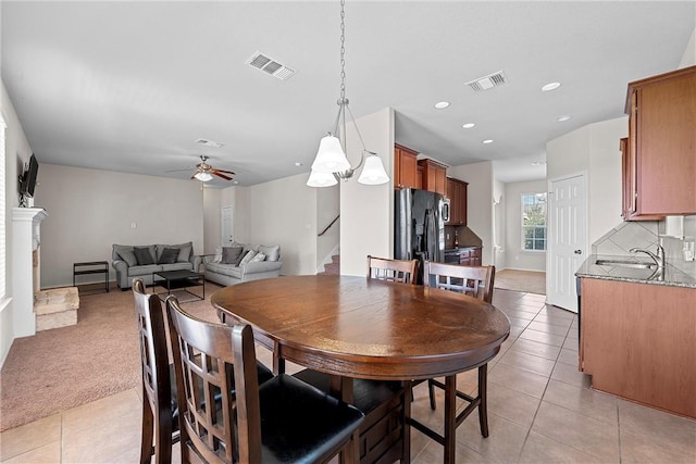 tiled dining room featuring ceiling fan and sink