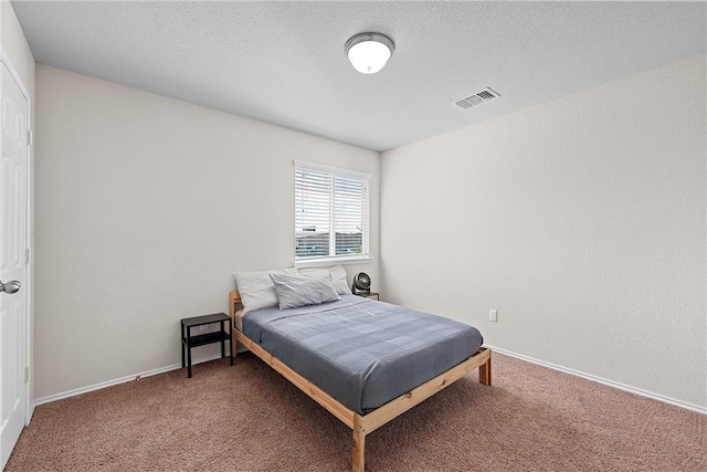 carpeted bedroom with a textured ceiling