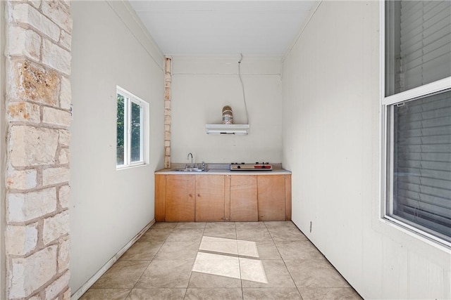 bar with light tile patterned floors, ornamental molding, and sink