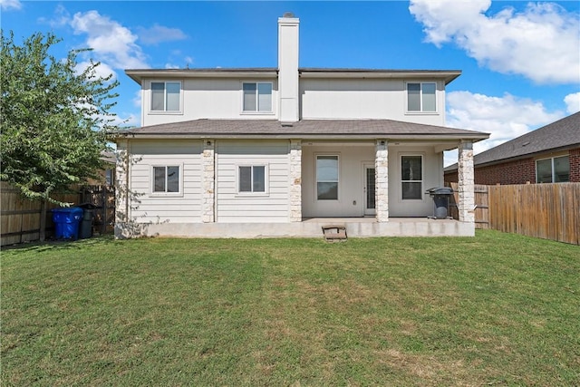 rear view of house with a lawn and a patio