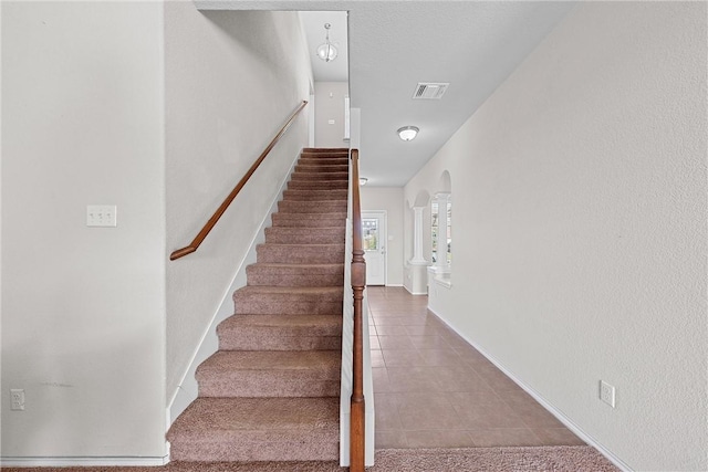 stairs with tile patterned floors