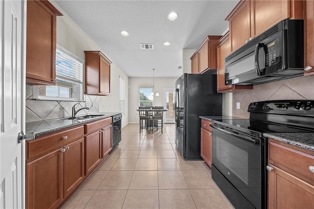 kitchen featuring light tile patterned floors, tasteful backsplash, a wealth of natural light, and black appliances