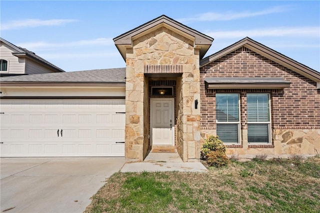 view of front of home with driveway, a garage, stone siding, roof with shingles, and brick siding