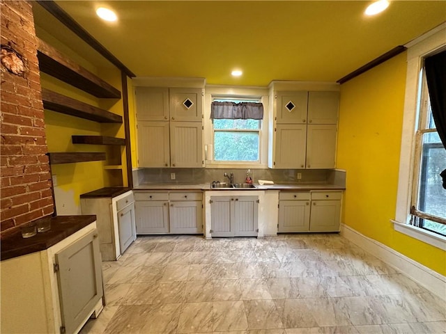 kitchen with decorative backsplash, sink, and crown molding