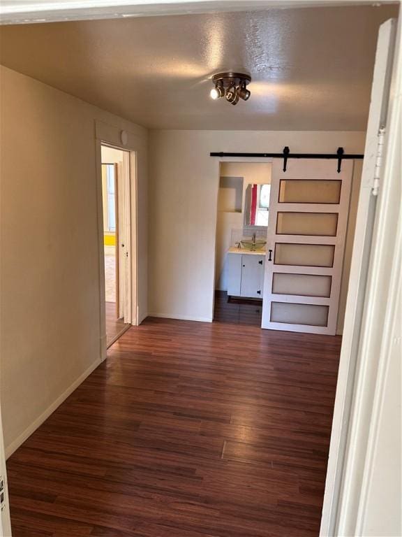 interior space with a barn door and dark wood-type flooring