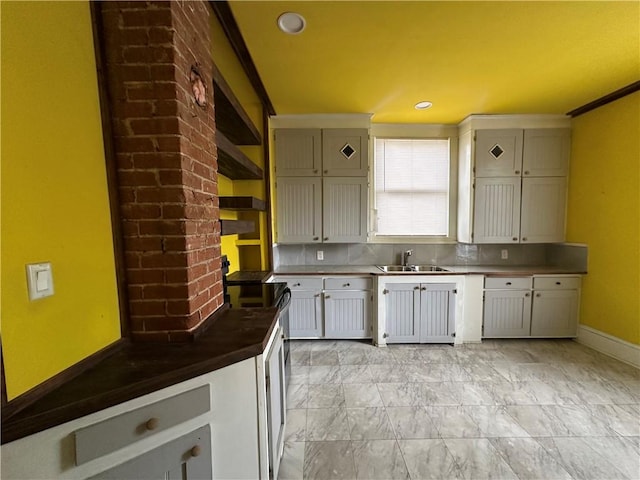 kitchen featuring range with electric stovetop, crown molding, sink, and tasteful backsplash