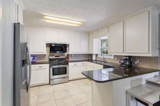 kitchen with kitchen peninsula, appliances with stainless steel finishes, sink, light tile patterned floors, and white cabinets