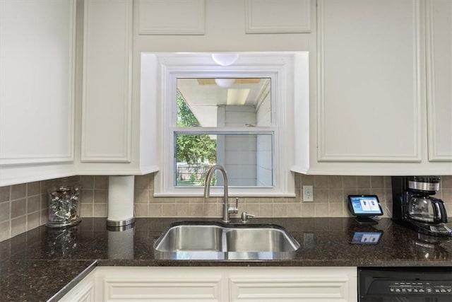 kitchen with tasteful backsplash, white cabinetry, sink, and black dishwasher