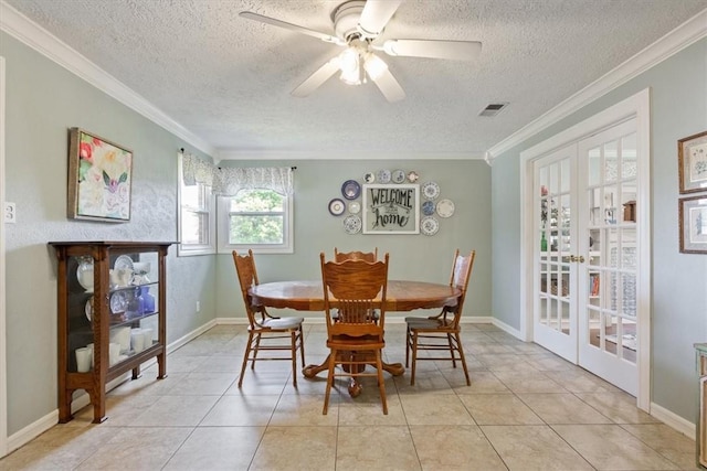 tiled dining area with french doors, a textured ceiling, ceiling fan, and ornamental molding