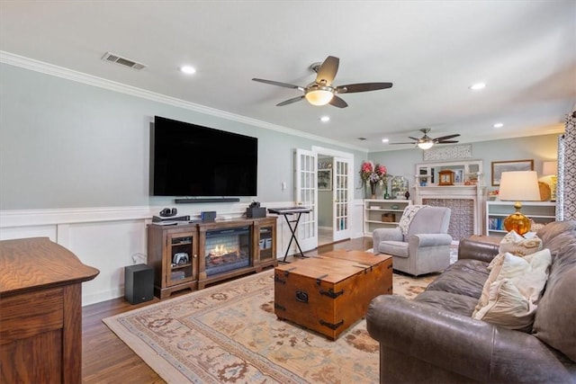 living room with hardwood / wood-style floors, french doors, ceiling fan, and crown molding