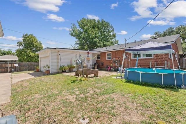 rear view of house featuring a fenced in pool and a yard