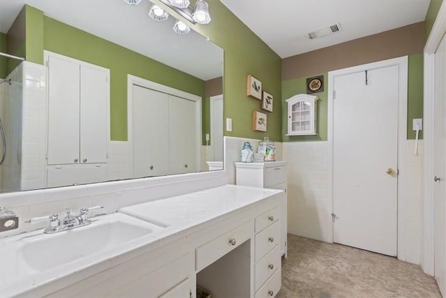 bathroom with vanity and tile walls