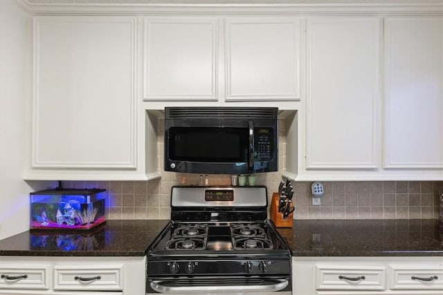 kitchen featuring white cabinets, decorative backsplash, stainless steel range with gas cooktop, and dark stone counters