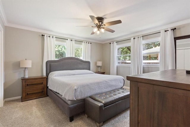 carpeted bedroom featuring ceiling fan and crown molding