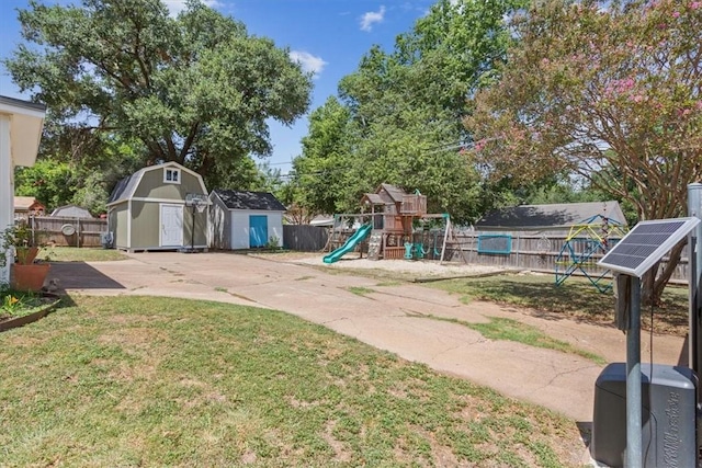 view of play area featuring a lawn and a shed