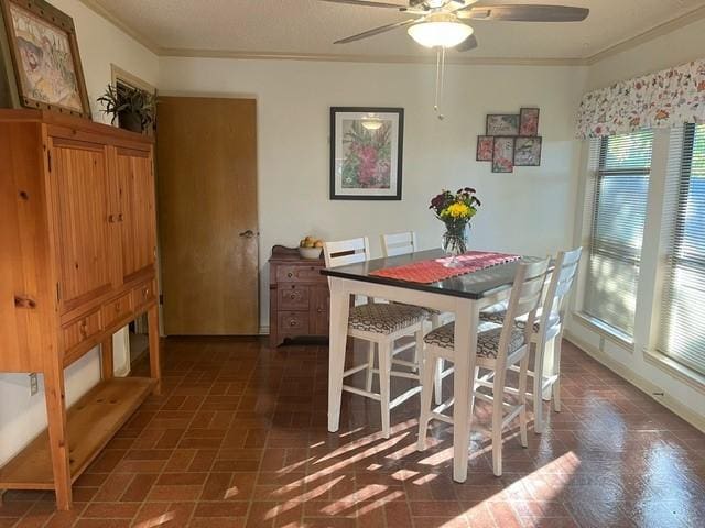 dining space featuring ceiling fan and ornamental molding