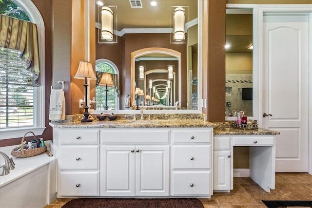 full bath with a tile shower, a washtub, vanity, and visible vents