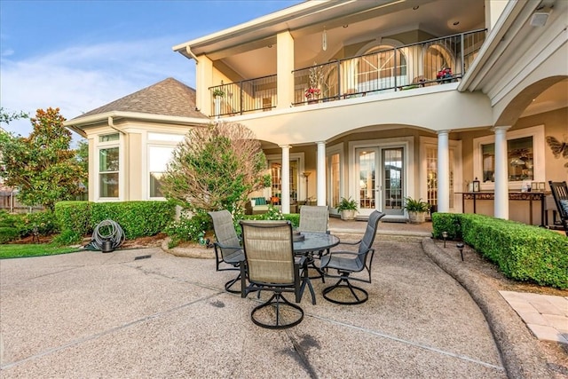 view of patio / terrace featuring a balcony, outdoor dining area, and french doors