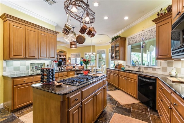 kitchen with decorative light fixtures, a kitchen island, sink, and black appliances