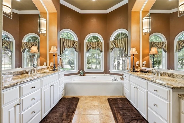 full bathroom with ornamental molding, two vanities, a sink, and a bath