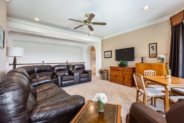 carpeted living room with ornamental molding and ceiling fan