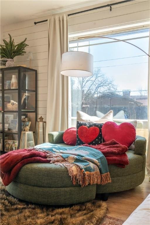 bedroom with hardwood / wood-style flooring and wood walls