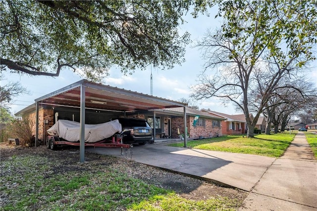 view of vehicle parking with a carport and a lawn