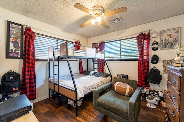 bedroom with multiple windows, hardwood / wood-style flooring, and a textured ceiling