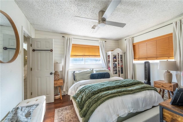 bedroom featuring ceiling fan, dark hardwood / wood-style flooring, and a textured ceiling