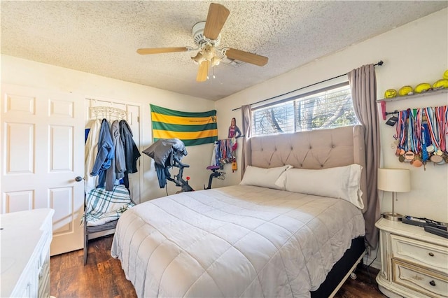 bedroom with ceiling fan, a textured ceiling, and dark hardwood / wood-style flooring