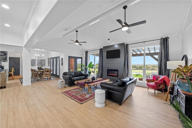 living room featuring plenty of natural light, ceiling fan with notable chandelier, and light hardwood / wood-style flooring