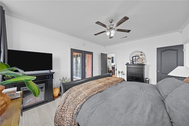 bedroom featuring ceiling fan, light wood-type flooring, and ornamental molding