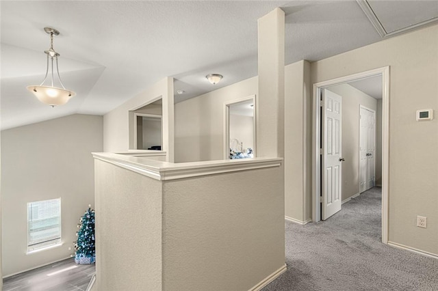 hallway featuring carpet flooring and lofted ceiling