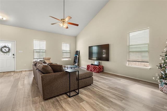 living room with light wood-type flooring, high vaulted ceiling, and ceiling fan