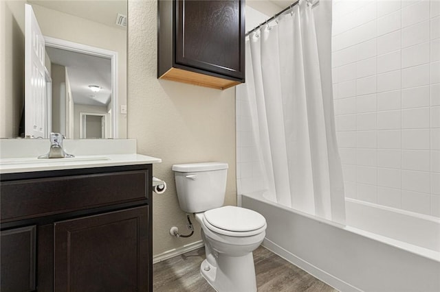 full bathroom featuring vanity, toilet, wood-type flooring, and shower / tub combo