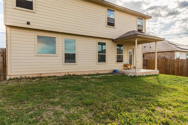 rear view of house with a lawn and a patio